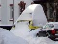 Wenn Autos, Fußgänger und der Schnee um den Platz auf der Straße konkurrieren